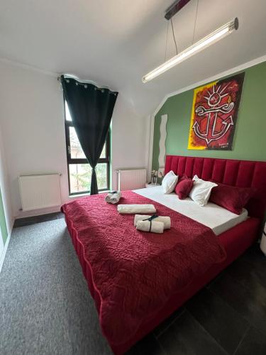 a bedroom with a large bed with a red bedspread at Vitamine Central Apartment in Craiova