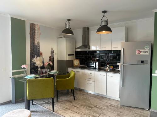 a kitchen with a table and a refrigerator at Vitamine Central Apartment in Craiova