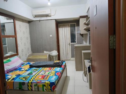 a small room with a bed with a keyboard on it at Bram Rooms Green Lake View Ciputat in Pondokcabe Hilir
