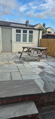a picnic table on a patio in front of a house at Amaryllis Escapes in Brecon