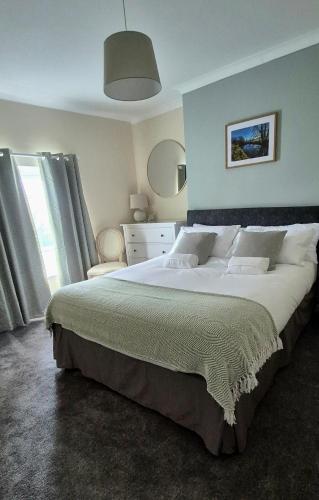 a bedroom with a large bed and a large window at Amaryllis Escapes in Brecon