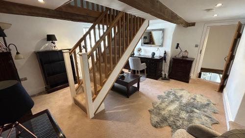 a living room with a staircase and a room with a desk at Farmhouse - Sleeps 6 - Near Alton Towers Peak Dist in Waterfall