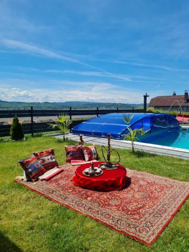 a picnic on a blanket in the grass next to a pool at Vienna Rem in Lukavac