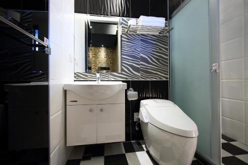 a bathroom with a toilet and a sink and a mirror at Buckingham Palace B&B in Beipu