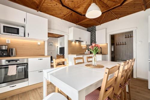 a kitchen and dining room with a white table and chairs at Chalupa pod stromy in Kovářská