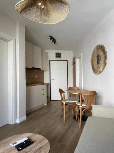 a kitchen and a dining room with a table and chairs at Apartmani Jedro in Rafailovici