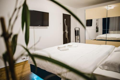 Un dormitorio con una cama blanca y un espejo. en Melissa Home, en Bucarest