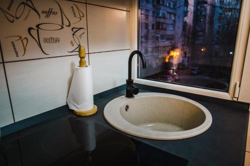 Un lavabo en un baño con ventana. en Melissa Home, en Bucarest