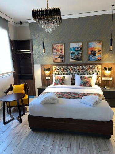 a bedroom with a large bed and a chandelier at Amirale in Oran