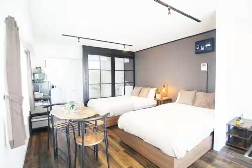 a bedroom with two beds and a table in it at AkasakaStay in Tokyo