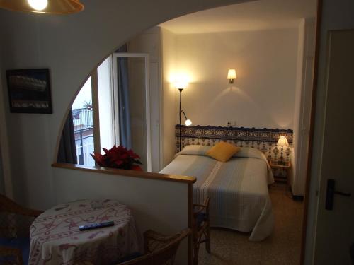 a bedroom with a bed and a mirror and a window at Apartamentos Montserrat in Sitges