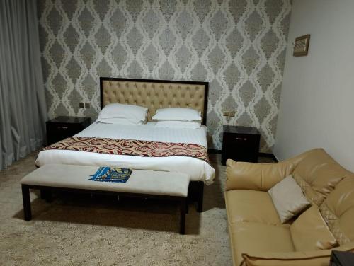a bedroom with a bed and a couch at فندق مرايا بارك in Najran
