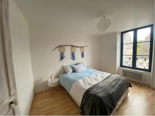 a white bedroom with a bed and a window at chez Alain et Sylvie in Braine