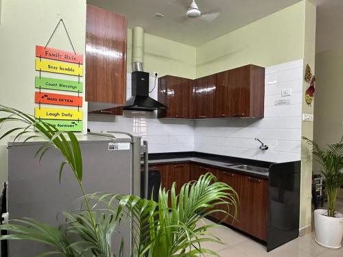 Una cocina con gabinetes de madera y un refrigerador de acero inoxidable. en Veridian Villa, en Kānpur