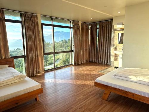 a bedroom with two beds and a large window at Sherpa Hills in Kathmandu