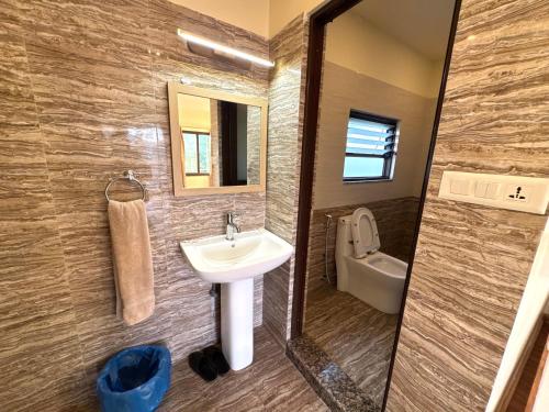 a bathroom with a sink and a toilet and a mirror at Sherpa Hills in Kathmandu