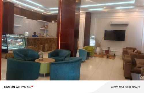 a waiting room with chairs and a table and a tv at رندة المدن للشقق المخدومة in Jazan