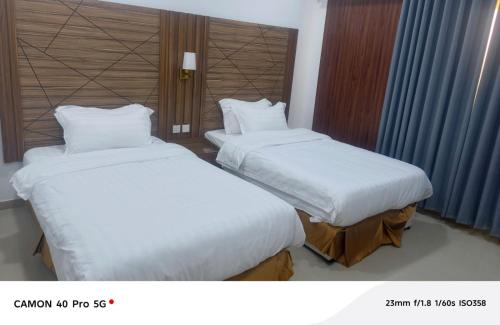 two beds sitting next to each other in a hotel room at رندة المدن للشقق المخدومة in Jazan