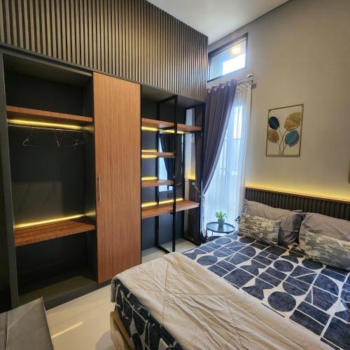 a bedroom with a bed and shelves and a window at Villa Yo and By in Karangploso