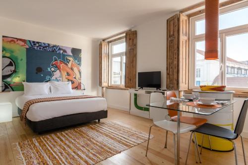 a bedroom with a bed and a desk and a table at Chiado Arty Flats in Lisbon