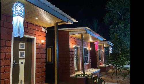 una casa de ladrillo con una puerta iluminada por la noche en Coastal Home, en Diveagar