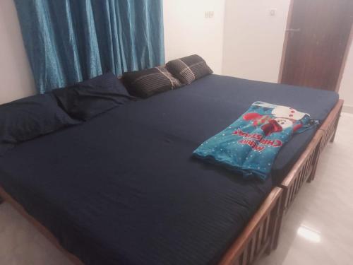 a bed with a black bedspread and a book on it at Dev And Ganga Homes in Trichūr