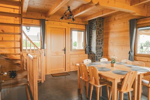 a dining room with a wooden table and chairs at Dziki Raj - domki z widokiem na Tatry oraz Babią Górę in Jabłonka