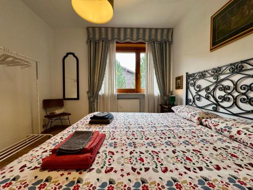 a bedroom with a large bed with a floral bedspread at Ampio appartamento per 8 a due passi dal centro in Bardonecchia