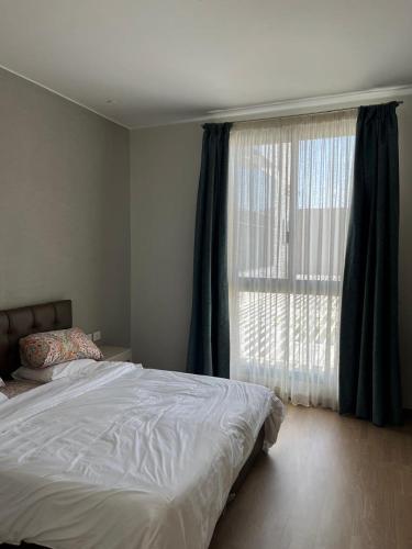 a bedroom with a bed and a large window at Aeon Towers 2BR in Sheikh Zayed