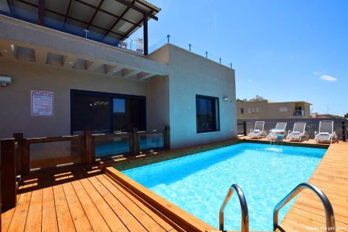 a large swimming pool on a deck next to a house at סוויטת אפנדי in Ya‘ara