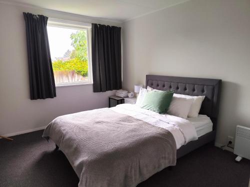 a bedroom with a large bed with a window at 3 Bedroom and big yard in Hamilton