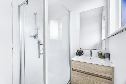 a bathroom with a sink and a shower with a mirror at 3 Bedroom and big yard in Hamilton