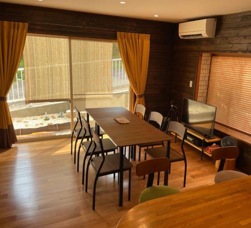 une salle à manger avec une table, des chaises et une télévision dans l'établissement Rio Grande - Vacation STAY 24026v, à Higashiizu