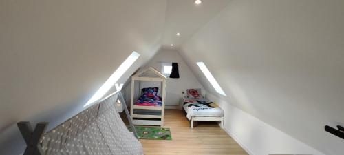 een zolderkamer met een trap met een stapelbed bij Maison moderne et chaleureuse à Colmar in Colmar