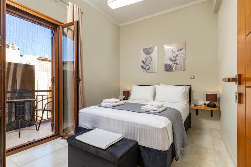 a bedroom with a bed and a balcony at Harbour, the Unique Chania Old Town Apt in Chania Town