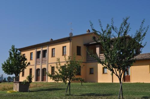 a large yellow building with trees in front of it at Il Casale Giallo in Montefalco