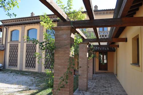 a pergola in front of a house at Il Casale Giallo in Montefalco