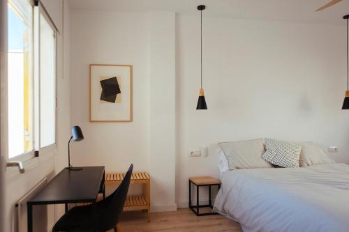 a bedroom with a bed and a desk and a chair at HORIA -Sundrenched apartment with terrace in Cabo de Gata in El Pozo de los Frailes