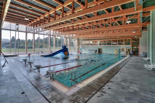 a large swimming pool in a large building at Hôtel Le Bec Bed and Chocolate self check-in in Fleurier