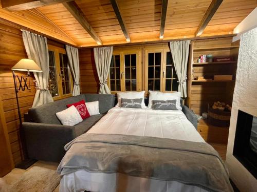a bedroom with a large bed and a couch at Gstaad Chalet in Gstaad