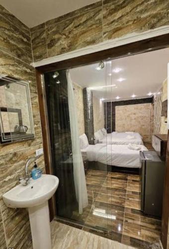 a bathroom with a sink and a shower and a bed at Hany pyramids view in Cairo
