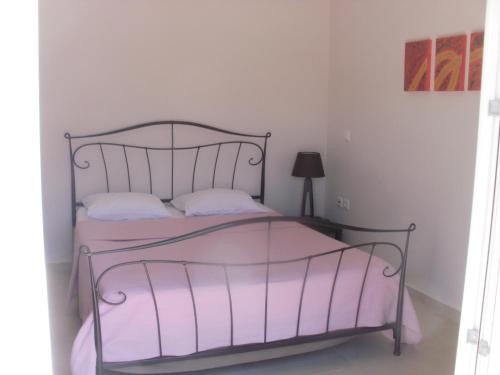 a bedroom with a bed with a metal frame at Afroessa Studios & Apartments in Samos