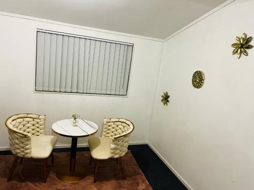 a table and chairs in a room with a window at Mount Breeze in Mount Maunganui