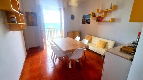 cocina con mesa, sillas y sofá en casa vacanze Cristoforo Colombo Holiday, en Trani