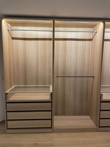 a closet with wooden doors and shelves at Your exclusive 2 room & 2 bathroom natural holiday home in Winterthur