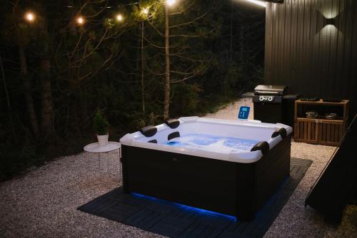a jacuzzi tub in a garden at night at Pinelle Blidinje A-Frame House in Risovac