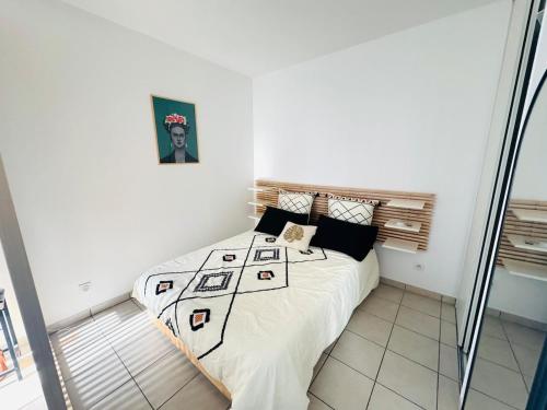 a bedroom with a bed in a white room at Le Faure - Appartement Centre ville et Jardin 2 personnes in Valence