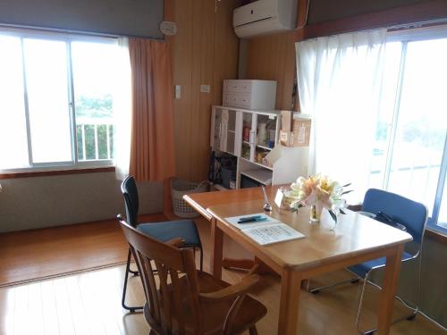 a dining room with a table and chairs at 二段ベッドの宿青と白 in Aki