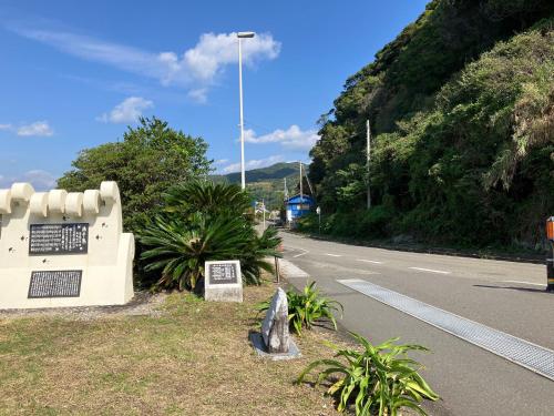 a sign on the side of a road at 二段ベッドの宿青と白 in Aki