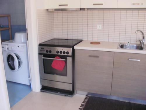 a kitchen with a stove with a red tag on it at Afroessa Studios & Apartments in Samos